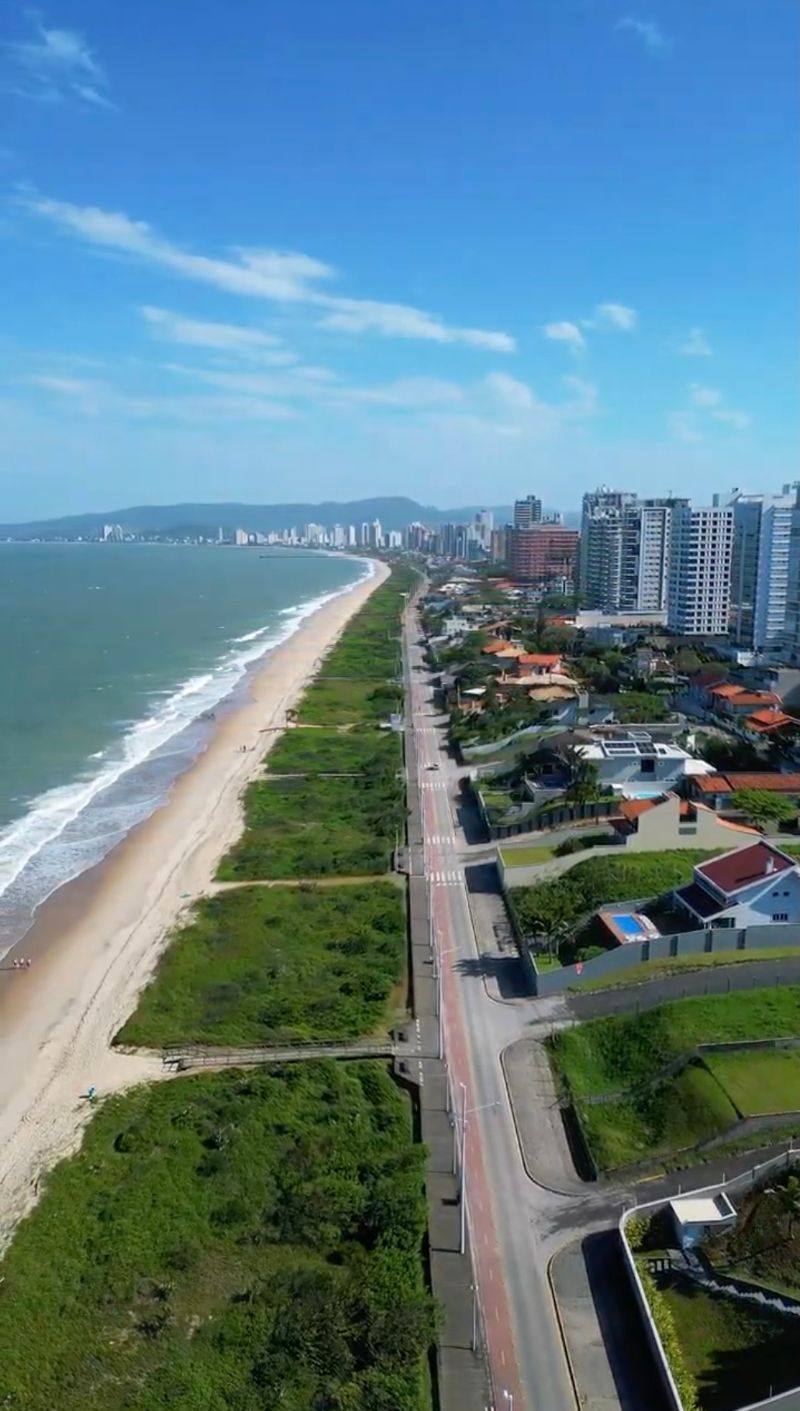 Praia com Bandeira Azul em Balneário Piçarras vista de drone, com a faixa de areia e os prédios ao fundo